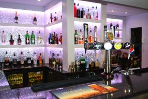 a bar with a bunch of bottles on the wall at Lyndene Hotel in Blackpool