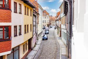 ulica w mieście z budynkami i samochodami w obiekcie Domizile am Markt w mieście Quedlinburg