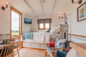 a bedroom with a bed and a table and chairs at Outbak Shepherds Hut in Cheltenham