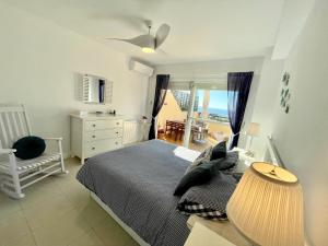 a bedroom with a bed and a chair and a window at Duplex-Townhouse en Marbella - vistas al mar -sea view in Cabopino