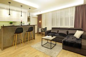 ein Wohnzimmer mit einem Sofa und einer Küche in der Unterkunft Paradise HARMONY LUX Apt-New Belgrade in Belgrad