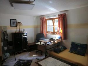 Habitación pequeña con escritorio y ventana. en Urlaub am Inn en Wasserburg am Inn