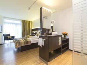 ハノーファーにあるコンコルド ホテル アム ライネシュロスのベッドルーム(ベッド1台、シンク、鏡付)