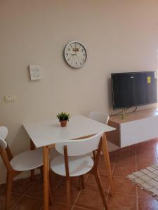 een eetkamer met een tafel en een klok aan de muur bij Standart apartment in Durrës