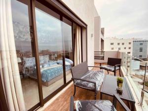 a room with a balcony with a view of a bedroom at Mogador Presidential Terrace - By AppartAli in Casablanca