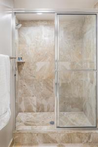 y baño con ducha y puerta de cristal. en The Atlantic Suites on the Ave, en Delray Beach