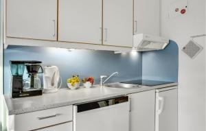 a kitchen with white cabinets and a sink at 3 Bedroom Cozy Apartment In Ringkøbing in Ringkøbing +13 photos