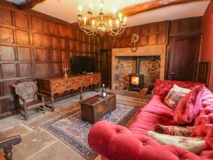 a living room with a red couch and a fireplace at Manor House in Leyburn