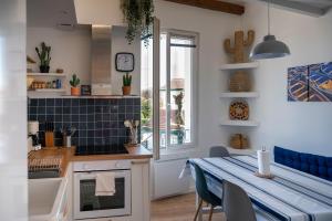 a kitchen with a table and a dining room at La Chouette du lac Marion in Biarritz