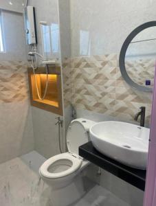 a bathroom with a white toilet and a sink at Cameron Homestay Adik Aisyah Purple Romance for Islam in Tanah Rata +12 photos