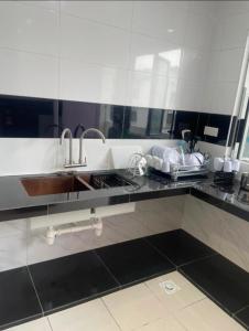 a kitchen with a sink and a large mirror at Cameron Homestay Adik Aisyah Purple Romance for Islam in Tanah Rata