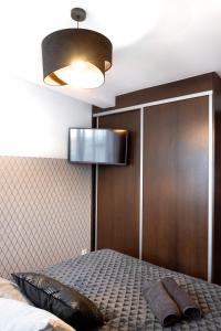 a bedroom with a bed and a light fixture at ClickTheFlat Piękna Center Apart Rooms in Warsaw