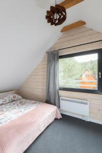 1 dormitorio con cama y ventana en Ostoja Notecka, en Wieleń