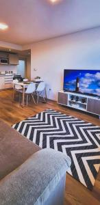uma sala de estar com uma grande televisão de ecrã plano em Estilo Ona Departamentos em Ushuaia