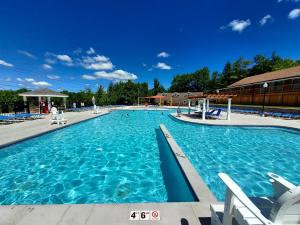una grande piscina con acqua blu di Chic and Stylish home Hot tub,4 bedrooms, game movie room, firepit, arcades, playground on site 2 min walk from pool and lake a Tobyhanna