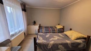 niewielka sypialnia z łóżkiem i oknem w obiekcie Felix- Hostel Pracowniczy w mieście Skierniewice