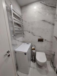 biała łazienka z toaletą i umywalką w obiekcie New Gudauri F4 w mieście Gudauri