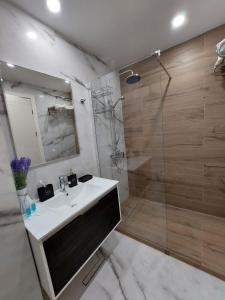 W łazience znajduje się biała umywalka i prysznic. w obiekcie New Gudauri F4 w mieście Gudauri