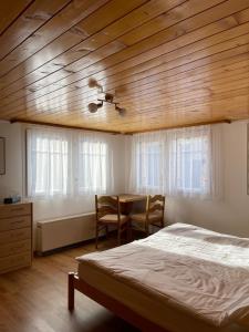 ein Schlafzimmer mit einem Bett, einem Tisch und Stühlen in der Unterkunft Moritzhaus in Grächen