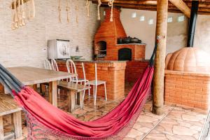 a hammock in a room with a table and an oven at Casa c conforto piscina e churrasqueira Atibaia in Atibaia