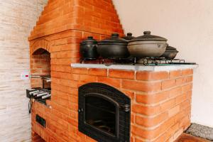 a brick oven with three pots on top of it at Casa c conforto piscina e churrasqueira Atibaia in Atibaia