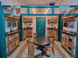 a dining room with a table and chairs and shelves at Shams House in Amman