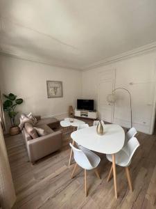 sala de estar con mesa, sillas y sofá en LE GALET BLANC cosy T2 en centre ville du Havre, en Le Havre
