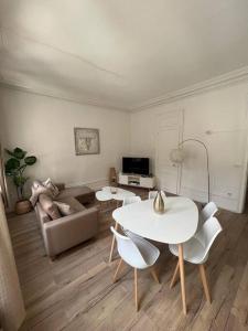 salon ze stołem, krzesłami i kanapą w obiekcie LE GALET BLANC cosy T2 en centre ville du Havre w Hawrze