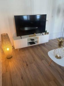 salon z telewizorem z płaskim ekranem i stołem w obiekcie LE GALET BLANC cosy T2 en centre ville du Havre w Hawrze +2 zdjęcia