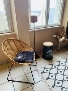 een stoel en een lamp in een kamer met een tapijt bij Appart'Crozon in Crozon