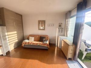 une chambre avec un canapé dans l'angle d'une pièce dans l'établissement AS22947-Studio cabine résidence direct sur plage, au Grau-du-Roi