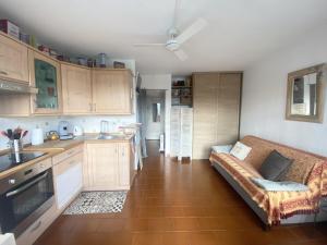 - une cuisine avec un canapé au milieu d'une pièce dans l'établissement AS22947-Studio cabine résidence direct sur plage, au Grau-du-Roi