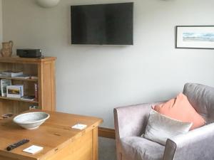 a living room with a couch and a table at Ebbas Neuk in Beadnell