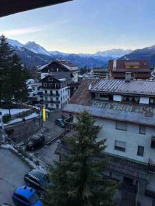 a city with cars parked in a parking lot with mountains at La Casa di Fede in Sauze dʼOulx