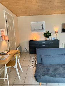 uma sala de estar com um sofá azul e uma mesa em Appart'Crozon em Crozon