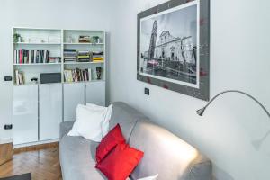 uma sala de estar com um sofá com almofadas vermelhas em Apple House al Duomo by Wonderful Italy em Turim