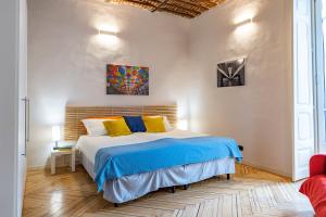 1 dormitorio con 1 cama con almohadas azules y amarillas en Apple House al Duomo by Wonderful Italy, en Turín