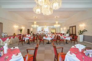 Savoy Spa & Kurhotel في فرانتيشكوفي لاذنه: غرفة طعام بها طاولات وكراسي وثريا