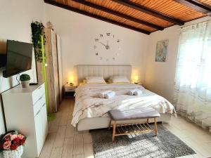 a bedroom with a large bed and a clock on the wall at Studio Apartment Lino in Skrbčići