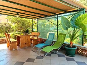 a screened in porch with chairs and a table at Studio Apartment Lino in Skrbčići