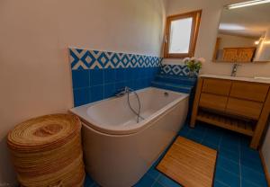 a blue and white bathroom with a tub and a sink at gite bioclimatique écologique in Sigonce