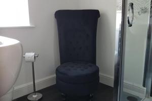 einem blauen Stuhl im Bad neben einer Dusche in der Unterkunft No6 High Street in Edwinstowe