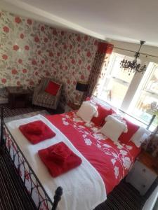 Schlafzimmer mit einem großen Bett mit roter und weißer Bettwäsche in der Unterkunft No6 High Street in Edwinstowe
