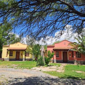 a pair of houses in a yard with trees at Cabañas SHAMBALLA in Cafayate