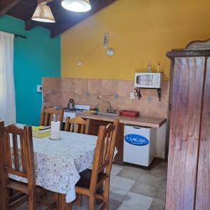 uma cozinha com uma mesa com cadeiras e um lavatório em Cabañas SHAMBALLA em Cafayate