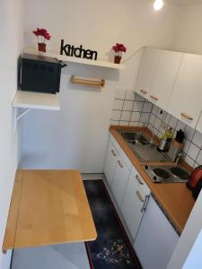 eine kleine Küche mit einem Küchenschild an der Wand in der Unterkunft CityApartment Platinum-Zentrum mit Parkplatz in Bielefeld