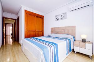 una camera bianca con un letto e una porta in legno di La Manga 2 Bedroom Apartment near the Beach a Murcia