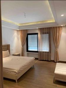 - une chambre avec un lit et une fenêtre avec des rideaux dans l'établissement S+3 luxurious apartment Hermes design in les jardins de Carthage Lac2, à Sidi Daoud