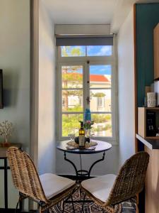 a table and two chairs in a room with a window at Old Port - Bellavista Studio in Chania
