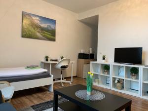 ein Wohnzimmer mit einem Bett und einem Tisch in der Unterkunft CityApartment Platinum-Zentrum mit Parkplatz in Bielefeld